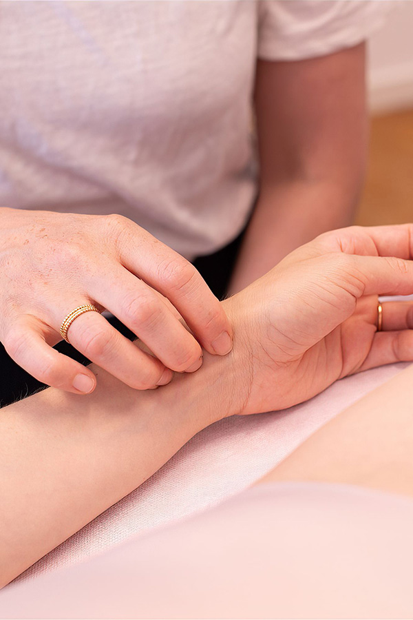 Florine Zingre behandelt per Akupressur am Arm einer Patientin